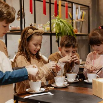 Kinder trinken Kakao beim Kerzen & Kakao Workshop in Wien
